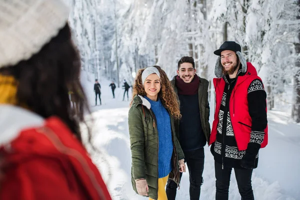 Un grupo de jóvenes amigos en un paseo al aire libre en la nieve en invierno . —  Fotos de Stock