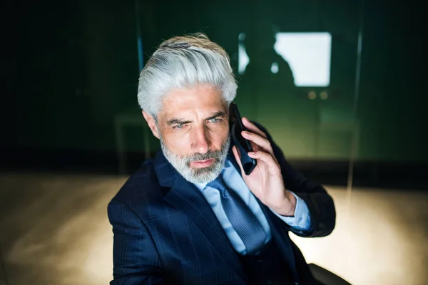 A portrait of mature businessman with smartphone in an office. — ストック写真