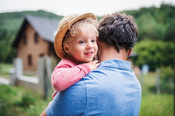 A close-up of father with toddler boy standing outdoors in garden in summer. — Stock Photo, Image