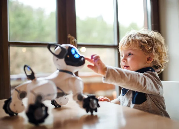 Evde dikilip robot köpekle oynayan tatlı bir çocuk.. — Stok fotoğraf