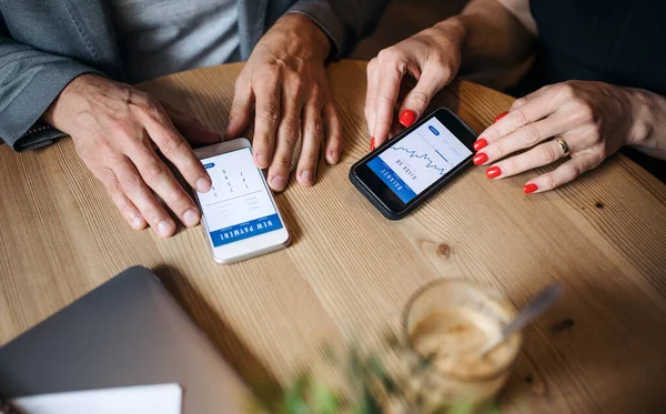 Midsection de empresários que têm reunião de negócios em um café, usando smartphones . — Fotografia de Stock