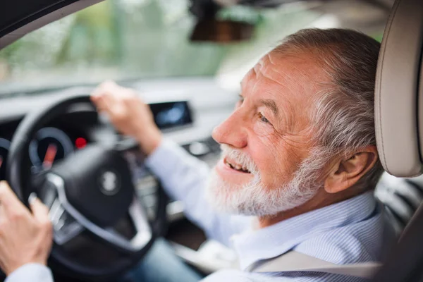 Primer plano del hombre mayor feliz sentado en el coche en el asiento del conductor, conduciendo . — Foto de Stock