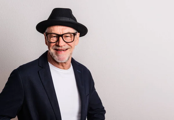 Ritratto di un anziano con cappello e occhiali in uno studio. Copia spazio . — Foto Stock