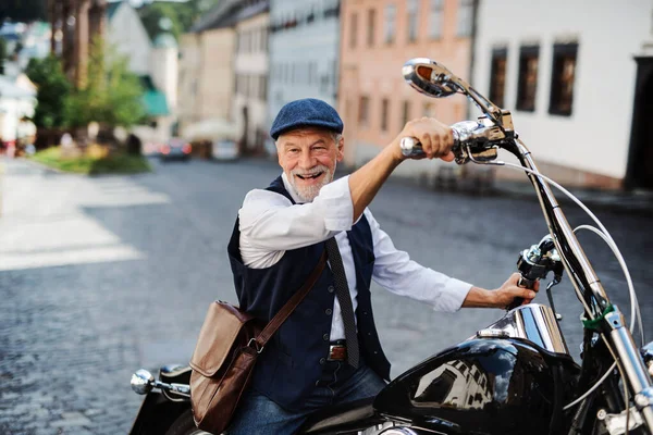 一个在城里骑摩托车的资深商人. — 图库照片