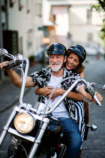 Веселая пожилая пара путешественников с мотоциклом в городе . — стоковое фото