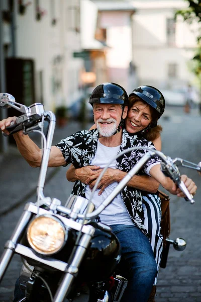 Kasabada motosikletli neşeli yaşlı çift gezginleri. — Stok fotoğraf