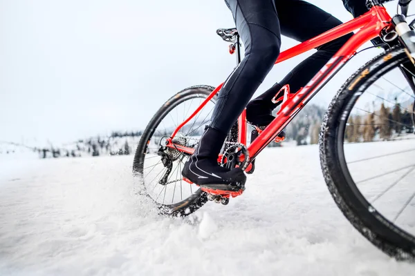 冬季在户外雪地里骑马的山地自行车的中段. — 图库照片