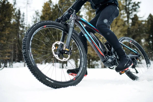 Midsectie van Mountain Biker rijden in sneeuw buitenshuis in de winter. — Stockfoto