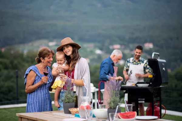 Familia multigeneración con vino al aire libre en el jardín barbacoa, parrilla . —  Fotos de Stock