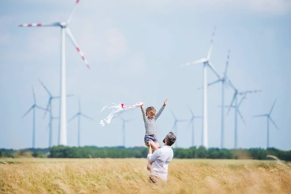 成熟的父亲与小女儿站在风电场的田野. — 图库照片