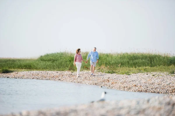 Senior par på en semester promenad vid sjön. Kopiera utrymme. — Stockfoto