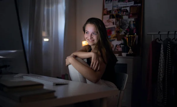 快乐的小女孩，晚上带着笔记本电脑，面带微笑，网上约会的概念. — 图库照片