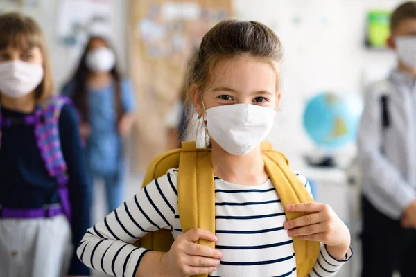 Criança com máscara facial voltando para a escola após quarentena e confinamento covid-19. — Fotografia de Stock