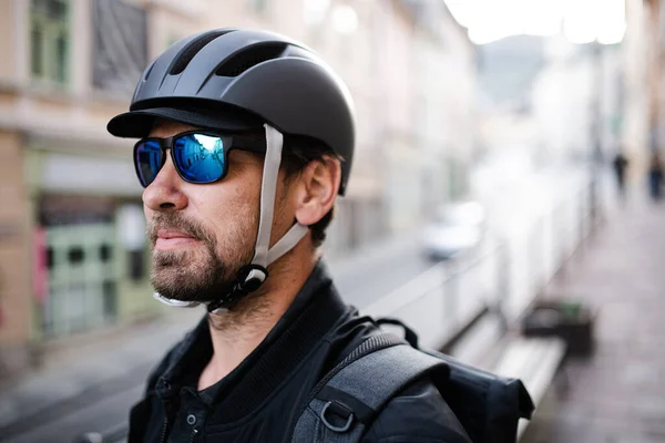Delivery man courier with bicycle helmet and sunglasses in town. — Stock Photo, Image