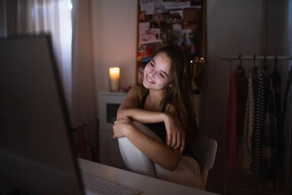 Chica joven feliz con la computadora en la noche sonriendo, concepto de citas en línea . — Foto de Stock