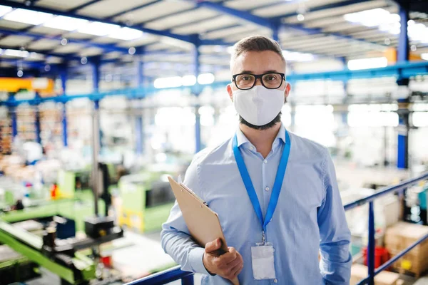 Τεχνικός ή μηχανικός με προστατευτική μάσκα εργασίας σε βιομηχανικό εργοστάσιο, όρθιος. — Φωτογραφία Αρχείου