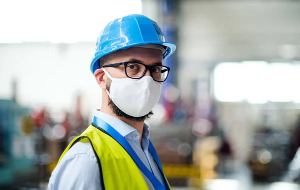 산업 공장에 서 있는 보호용 마스크와 헬멧을 쓰고 있는 기술자나 기술자. — 스톡 사진