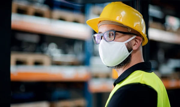 Tekniker eller ingeniør med beskyttelsesmaske og hjelm stående i industriel fabrik . - Stock-foto