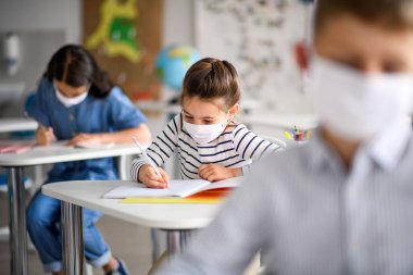 Yüzü maskeli çocuklar, karantina ve tecritten sonra okula geri döndüler..