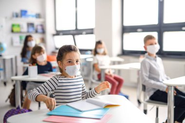 Yüzü maskeli çocuklar, karantina ve tecritten sonra okula geri döndüler..
