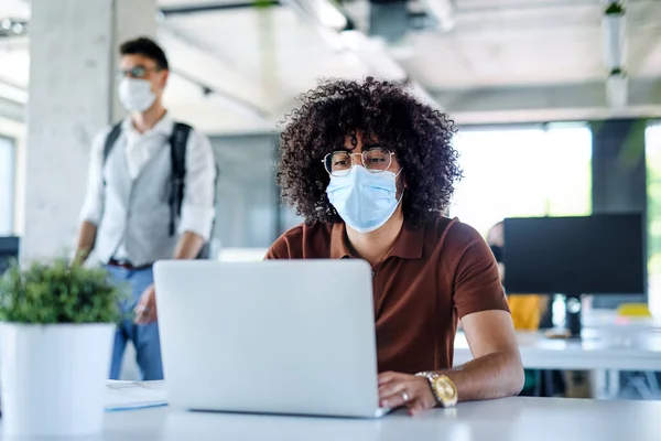 Portrait of young man with face mask back at work in office after lockdown. — Stock Photo, Image
