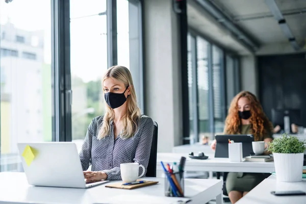 Young people with face masks back at work or school in office after lockdown. — Stock Photo, Image