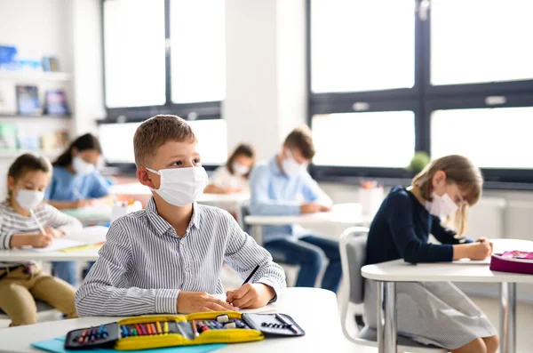 Niños con mascarilla en la escuela después de la cuarentena y el bloqueo de covid-19. — Foto de Stock