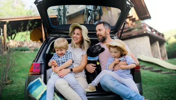 Famiglia con due bambini piccoli e cane in gita in bicicletta in campagna . — Foto Stock