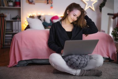 Bilgisayarında oturan, gülümseyen, online flört konsepti olan güzel mutlu genç kız..