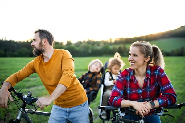 Familia con dos niños pequeños en viaje en bicicleta, divirtiéndose . — Foto de Stock