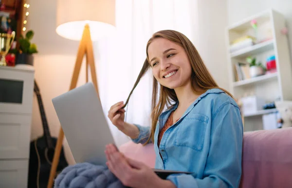 Счастливая молодая девушка с ноутбуком сидит и улыбается, концепция онлайн-знакомств . — стоковое фото