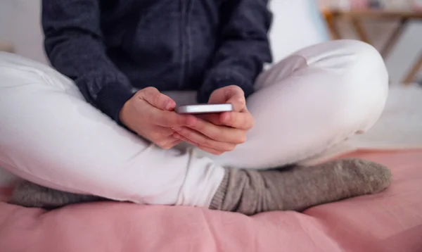 スマートフォンを屋内に持つ若い女の子の中間部,インターネット虐待の概念. — ストック写真