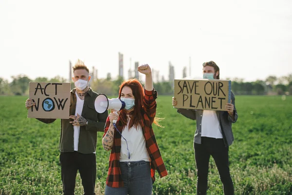 Grupo de jovens ativistas com cartazes em pé ao ar livre pela refinaria de petróleo, protestando . — Fotografia de Stock