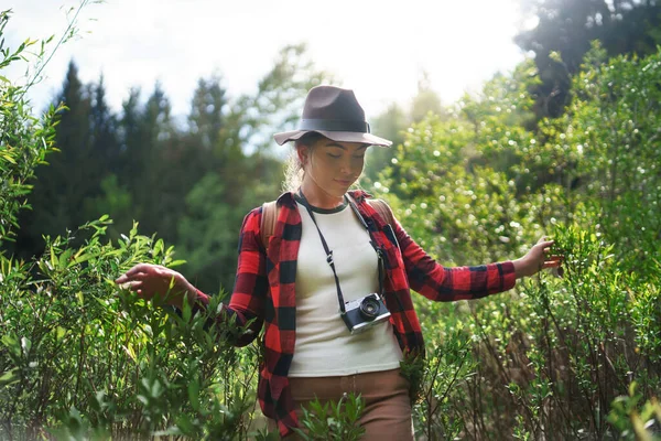 Ung kvinna med kamera på promenad i skogen i sommarnaturen, promenader. — Stockfoto