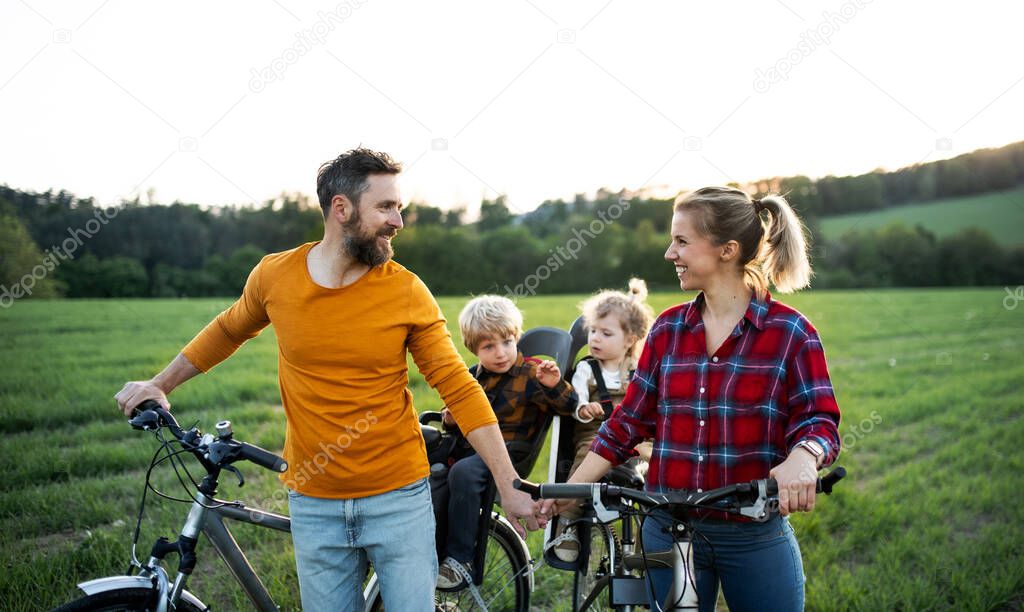 Family with two small children on cycling trip, resting.