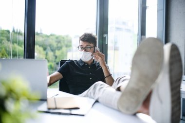 Yüzü maskeli genç adam iş yerinde ya da okulda tecritten sonra eğleniyor..