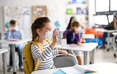 Yüzü maskeli kız, karantina ve tecritten sonra okula dönmüş..