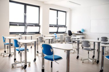 Özel okuldaki alışılmadık sınıflarda masalar.