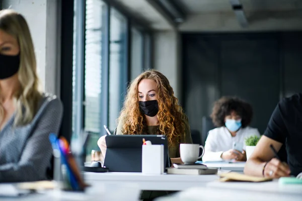 Young people with face masks back at work or school in office after lockdown. — Stock Photo, Image