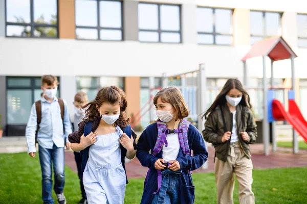 Children with face mask going back to school after covid-19 lockdown, walking outdoors. — Stock Photo, Image