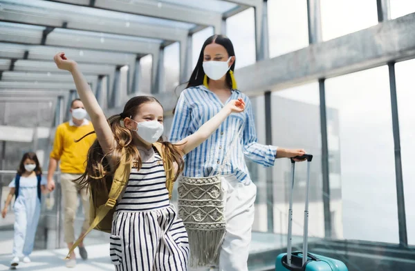 Familia con dos hijos de vacaciones, con mascarillas en el aeropuerto . — Foto de Stock