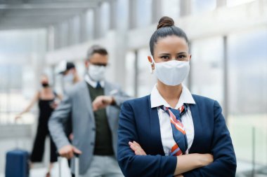 Havaalanında maske takan uçuş görevlisinin portresi..