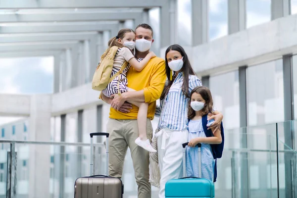 Сім'я з двома дітьми, які їдуть у відпустку, в аеропорту носять маски для обличчя . — стокове фото