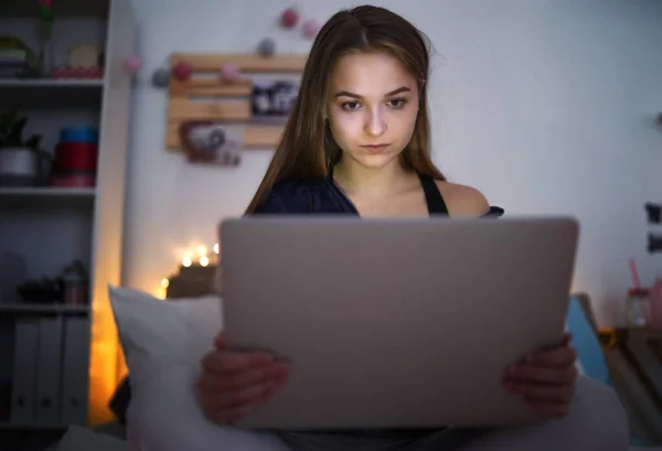 Chica joven triste y preocupado con el ordenador portátil sentado en el interior, concepto de abuso de Internet . — Foto de Stock