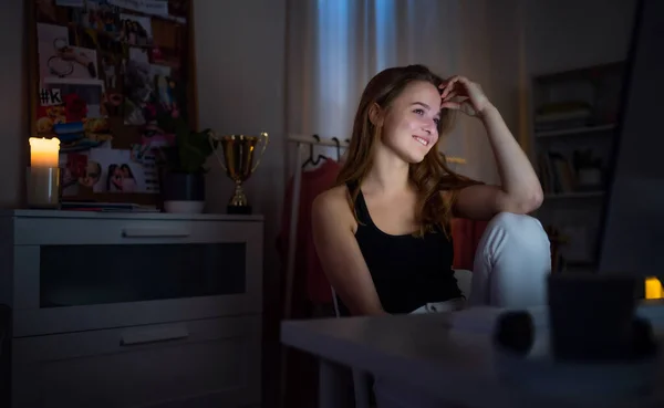 Chica joven feliz con la computadora en la noche sonriendo, concepto de citas en línea . — Foto de Stock