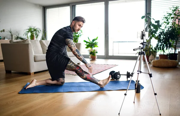Hombre entrenador haciendo ejercicio en línea en el interior de casa, utilizando la cámara . —  Fotos de Stock