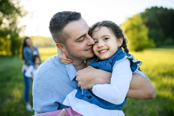 Padre jugando con hija pequeña al aire libre en la naturaleza de primavera, divertirse . — Foto de Stock