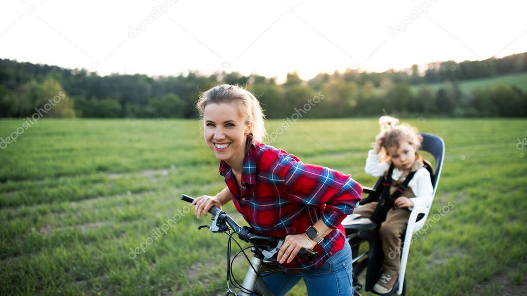 Mother with two small daughter on cycling trip, having fun.