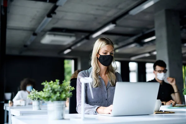 Young people with face masks back at work or school in office after lockdown. — Stock Photo, Image