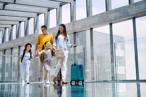 Familia con dos niños de vacaciones, caminando en el aeropuerto con equipaje . — Foto de Stock